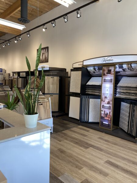 An interior view of the right side main area at Nufloors Kamloops, with the reception desk in the centre and flooring samples along the wall