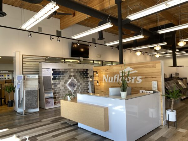 The store interior of Nufloors Kamloops, showing the front reception desk and Shaw Carpet flooring samples