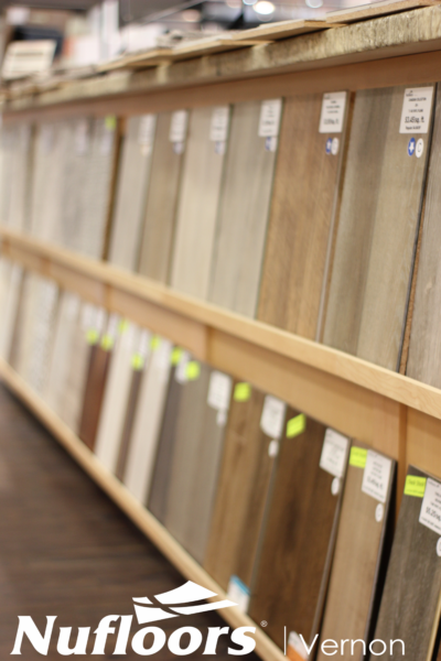Different types and styles of floor vinyls placed on a shelf.