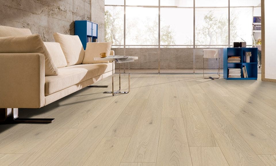 light wide plank hardwood flooring in a modern living room with stone tile walls and a peach coloured couch.