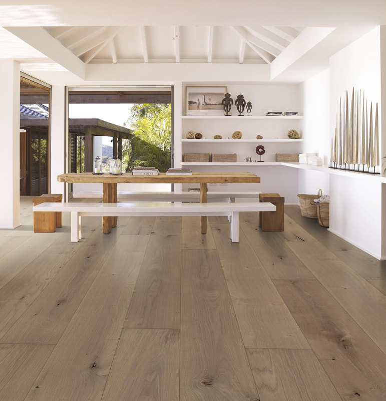 Wide plank wood flooring in a modern dining room, with views through to a courtryard and outdoor area