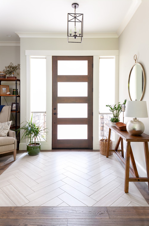 Herringbone tile pattern framed by wood in a home entryway, highlighting creative flooring