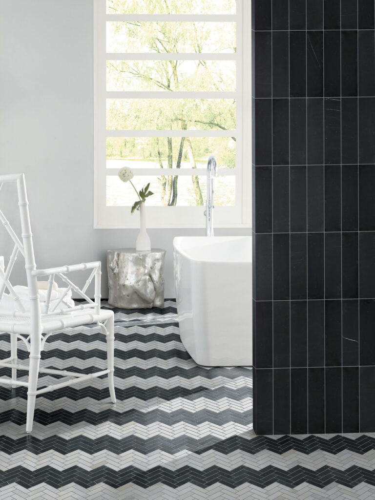 Zig-zag tile pattern creative flooring in a black and white bathroom, with vertical subway tiles on the wall