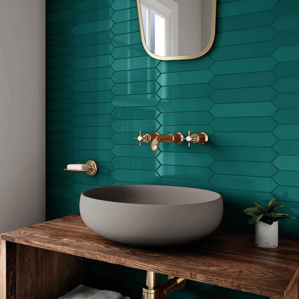 bright teal subway tile in a modern bathroom with gold hardware and a grey stone sink