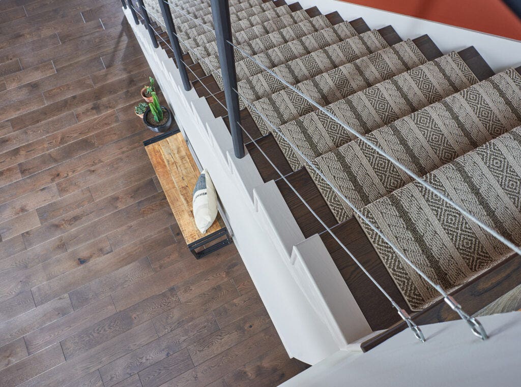 Carpet flooring on steps looking down from a landing, with a brown tribal pattern.