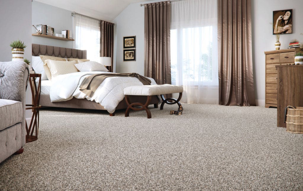 Bedroom with decor in different shades of brown and Nature's Elegance SmartStrand carpet by Mohawk, highlighting how fall weather can impact carpet