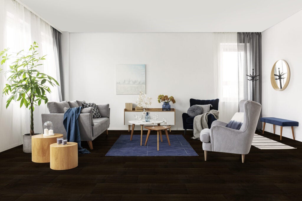 Dark waterproof laminate flooring in a living room, with modern grey furniture and wood accents