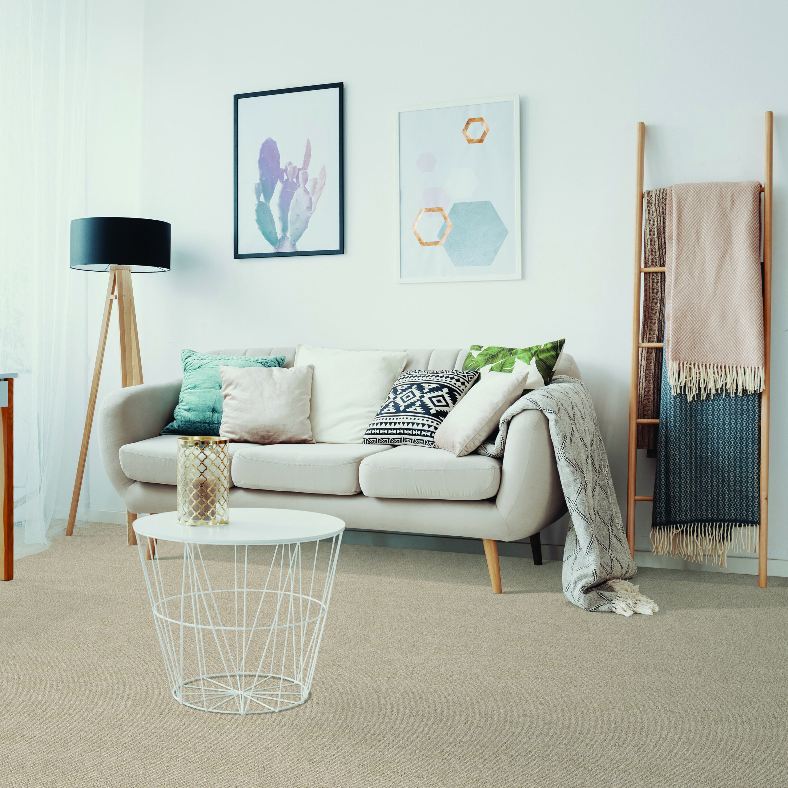 Carpet made by Beaulieu in Canada, showcased in a modern living room with a light couch, accent pillows and sand-coloured carpet.