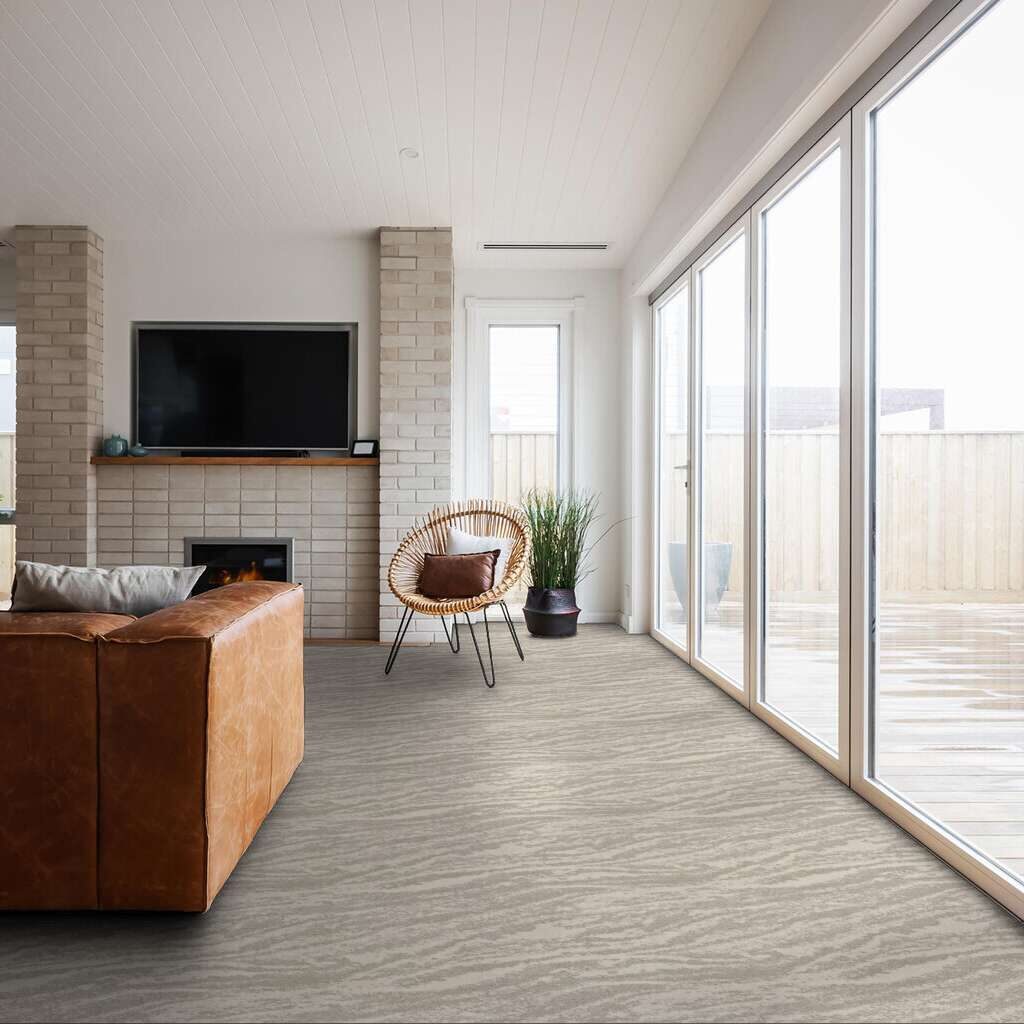Shaw velour carpet in the colour sugar crisp shown in a living room with large floor to ceiling windows.