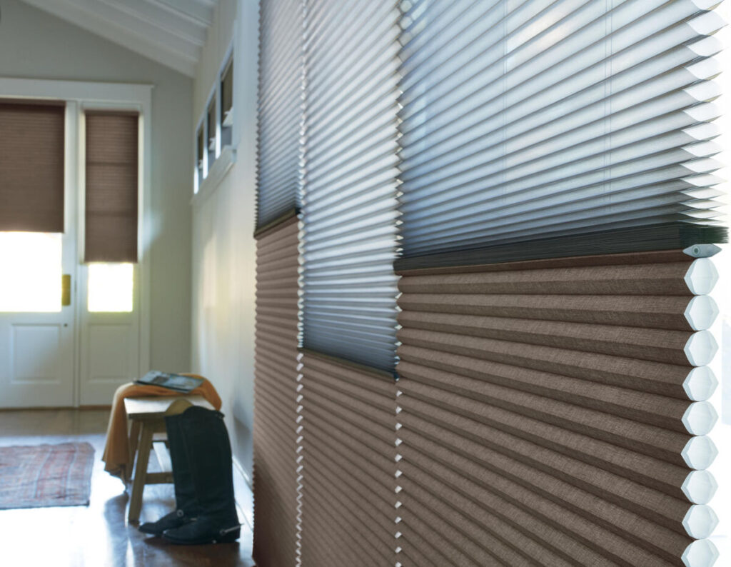 Light passing through honeycomb blinds in a front entrance, highlighting the energy cost savings by keeping thermal heat out in the summer, and keeping cold out in the winter. 