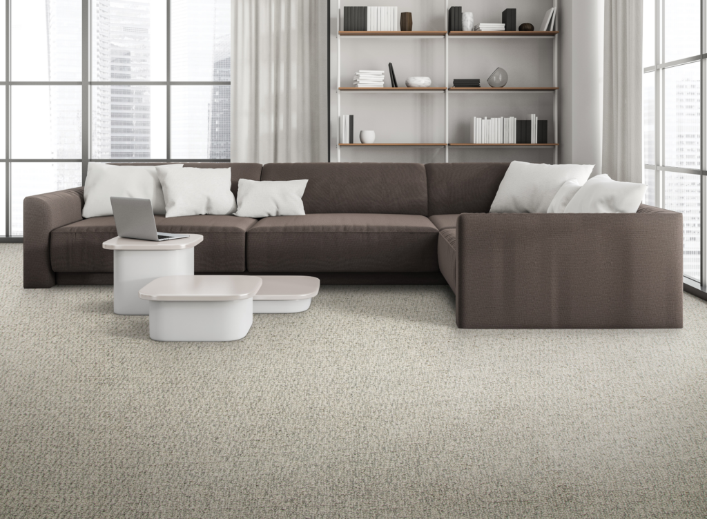 Everstrand carpet on display in a minimalist design living room, with a brown sof, light grey carpet and a white coffee table. 