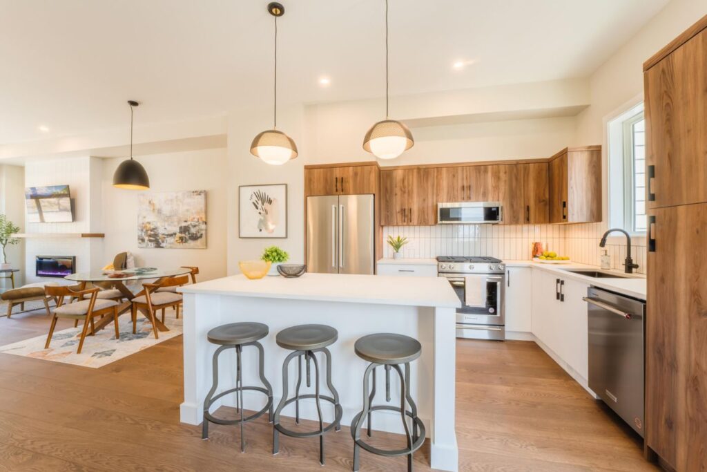 Photos of home interiors from Wilden, a premier developer in the city of Kelowna, including a kitchen and living room with wood accents and bright white and cream walls with modern lighting and flooring.