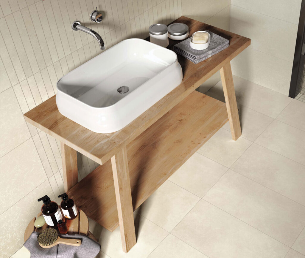 Ames tile in the Flux collection, featured in a beige bathroom with tile on the wall and floor, infront of a wooden stand-alone vanity