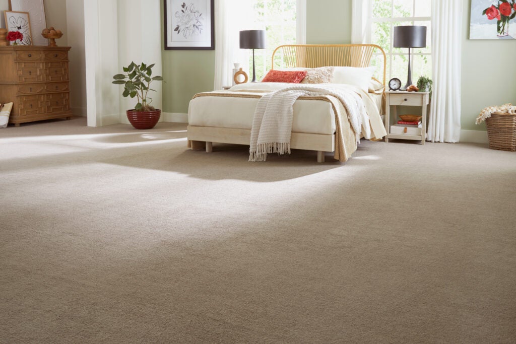 A bedroom with Mohawk's EverStrand carpeting, a sustainable choice using eco-friendly products and practices.