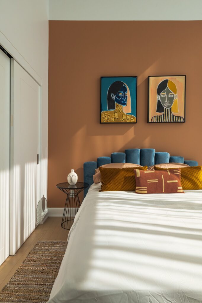 Bedroom with contrasting colour scheme in dark blues and a warm rust colour.