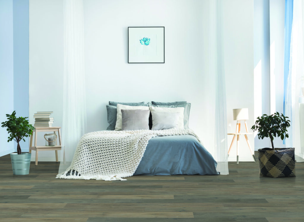 Bedroom with light blue, grey and white design scheme and dark hardwood flooring.