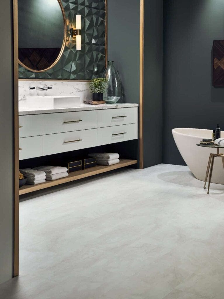 Bathroom with dark emerald walls, gold trim and white floors.