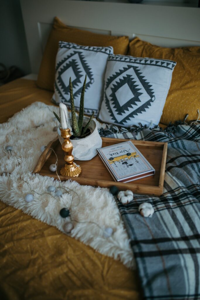 Bed with mustard yellow flannel sheets and fall inspired items.