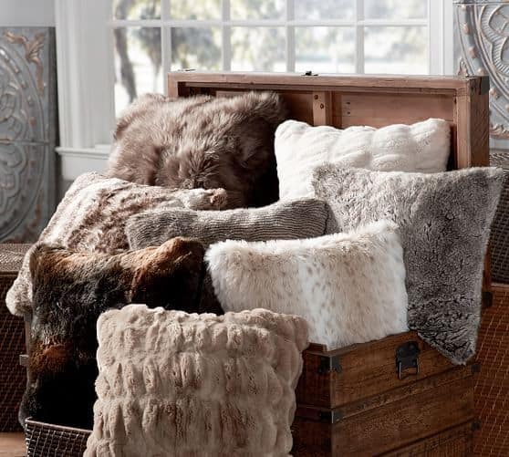 Cozy Faux Fur Pillows in a Rustic Trunk' highlighting perfect winter decor items.