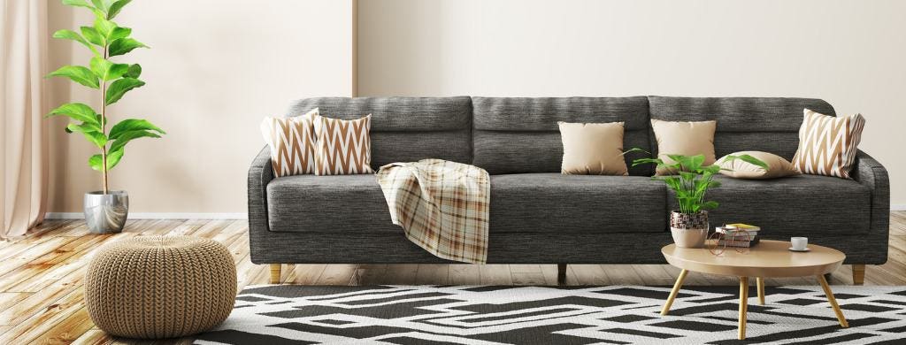 Interior of living room with sofa, rug, and wood flooring