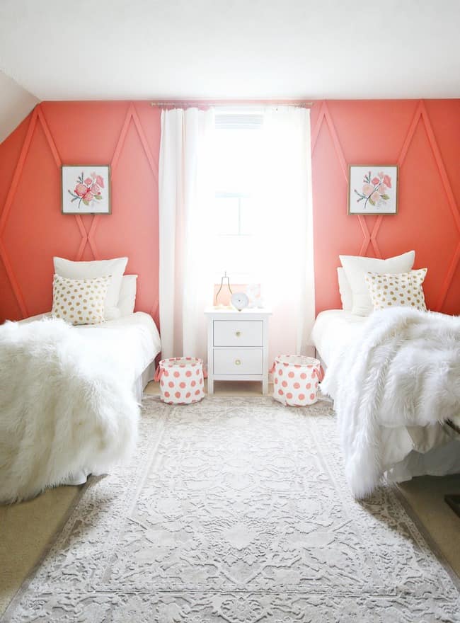 Kids bedroom with two beds and red walls.