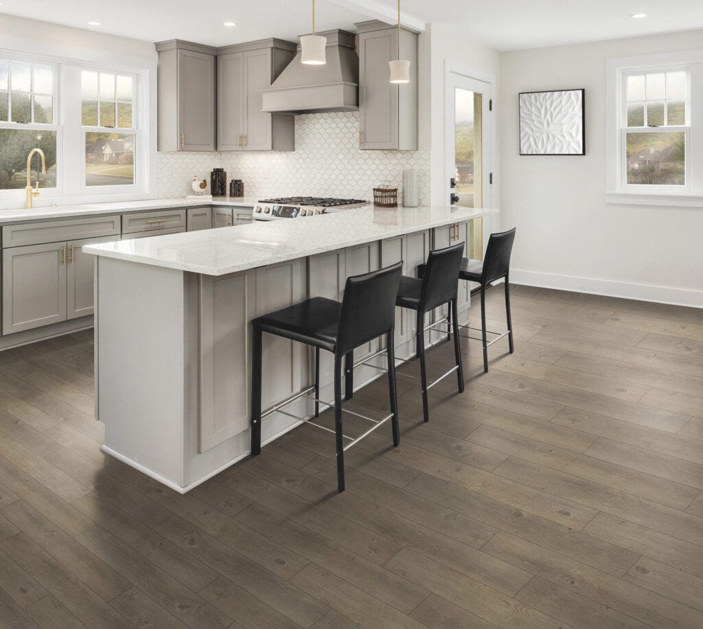 LVT Batavia Pine Crest Flooring in a light kitchen with white tile backsplash, a white stone countertop and light grey cabinets. 