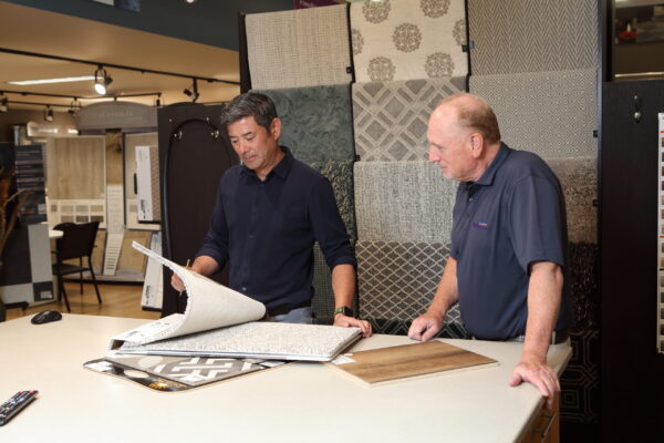 Vernon Nufloors Team Member Helping a Customer Look at Carpet Sample