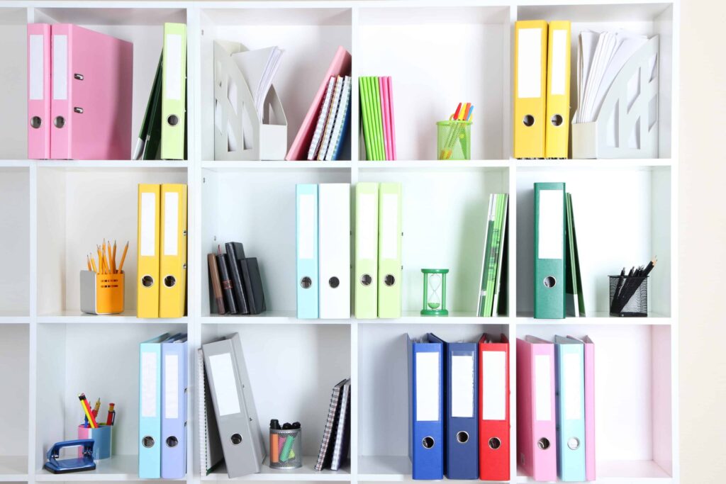 White Office cube shelves with folders and different stationery.