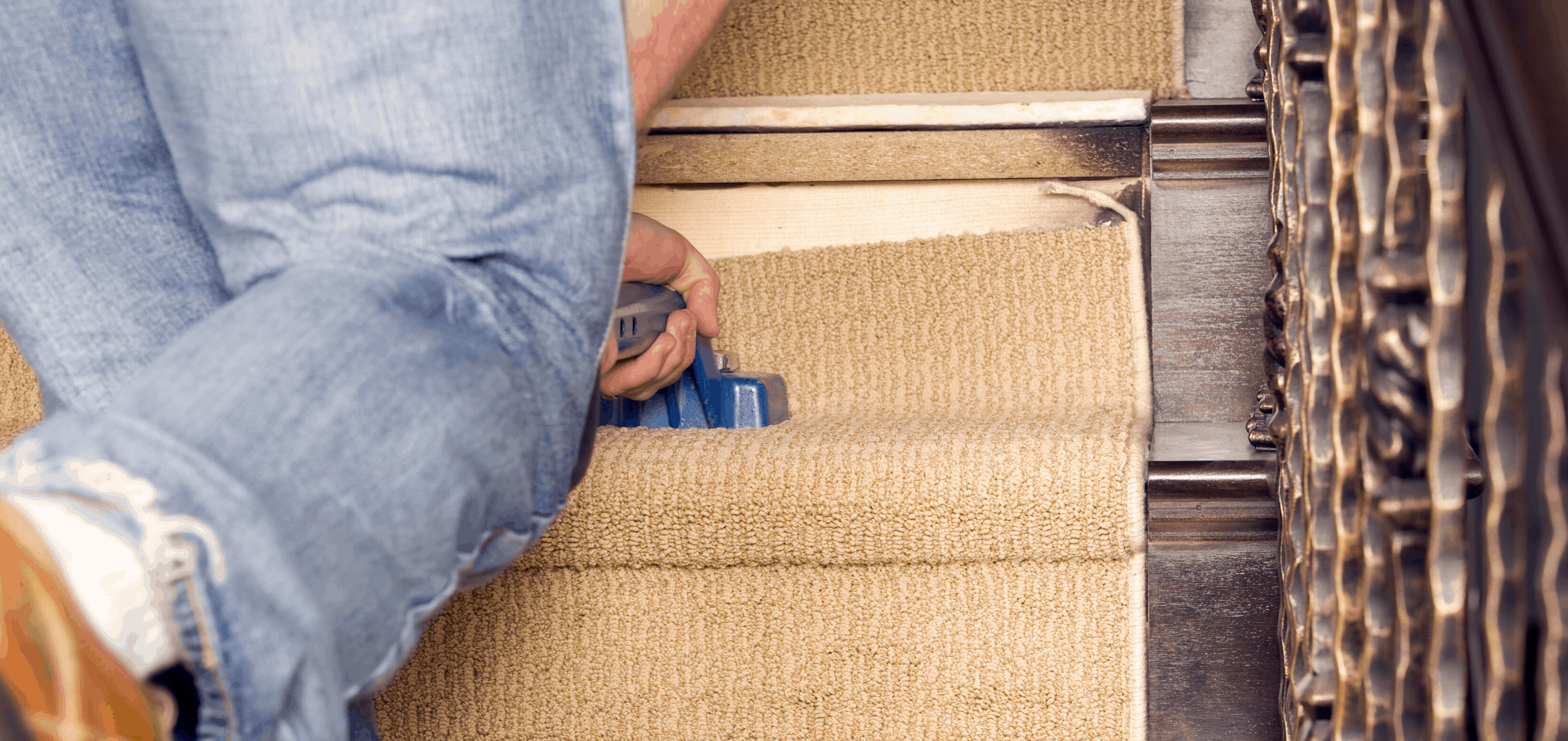 Person installing beige carpet on stairs.