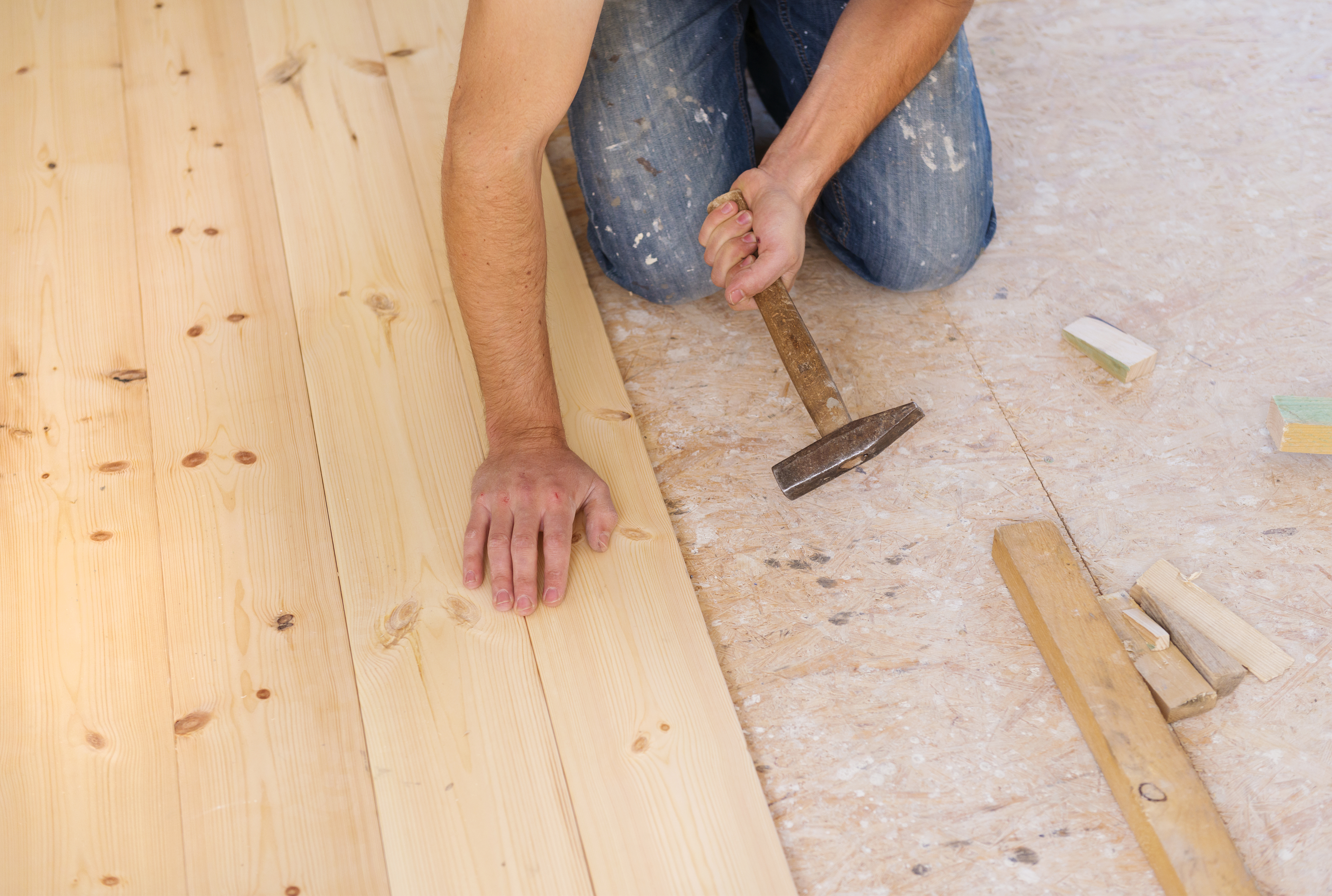 Person installing wood flooring.