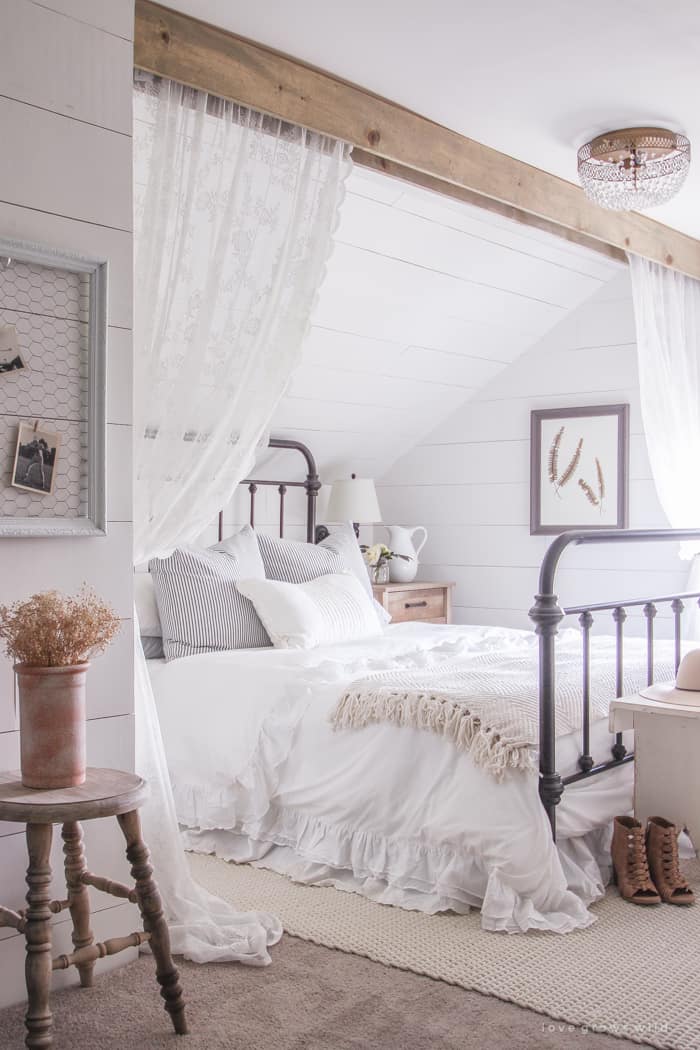 Farmhouse style bedroom with white shiplap walls.