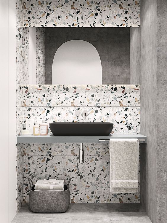 Bathroom with two concrete walls and floor, floating counter and two white tile walls.
