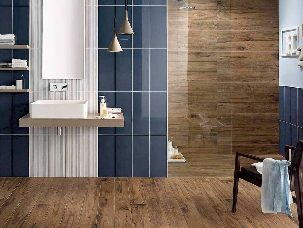 A bathroom with a wooden floor and ceramic wall tiles.