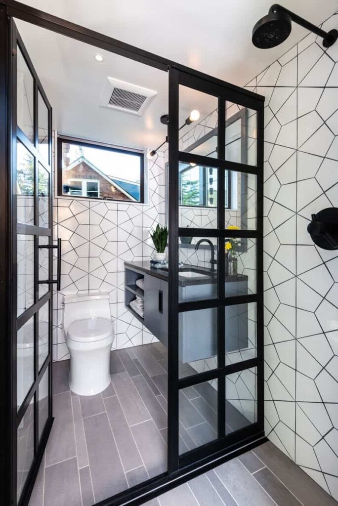 Washroom with white tiles and wooden floor.