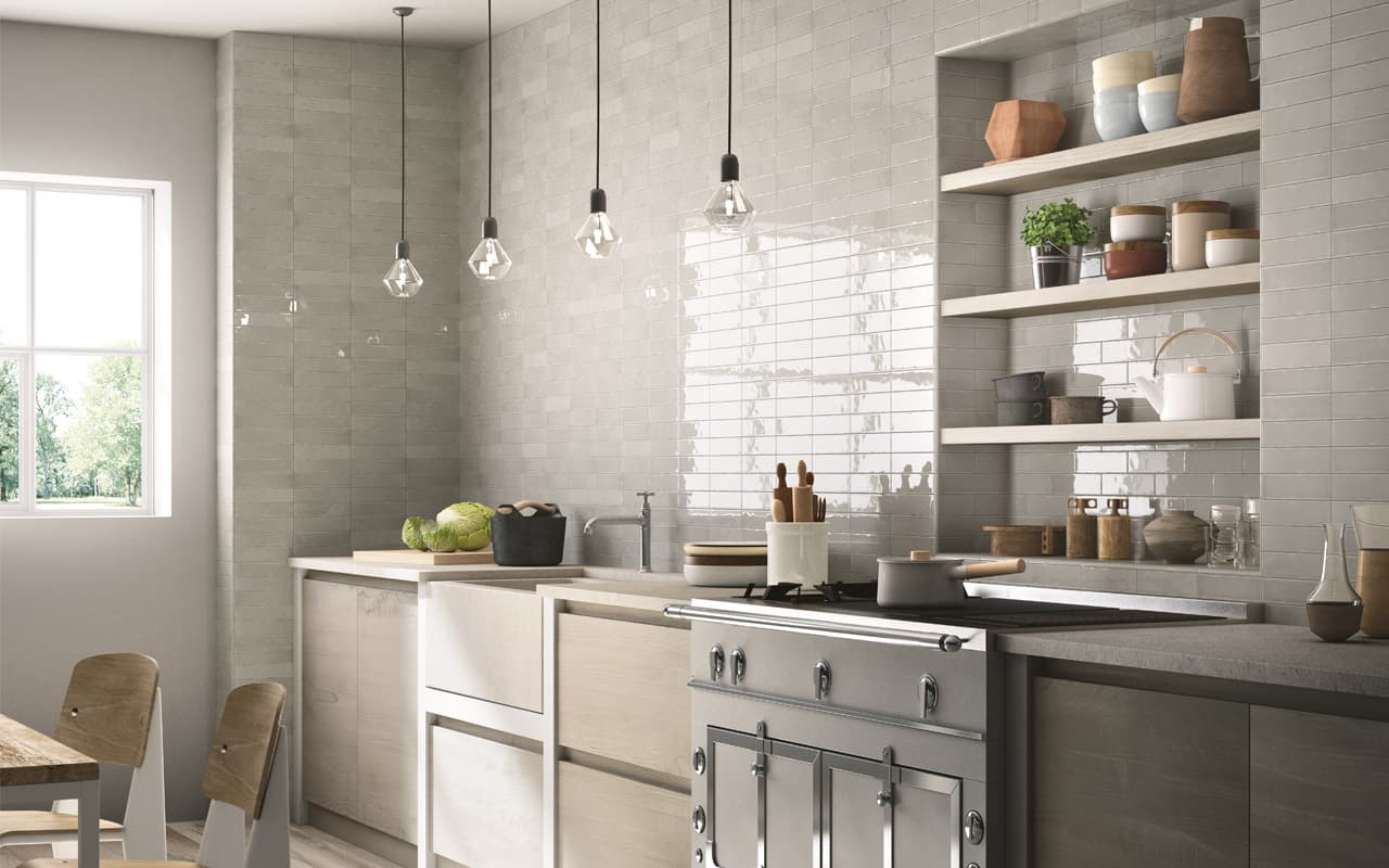 Monochromatic kitchen with light wood cupboards, off white tile with white grout