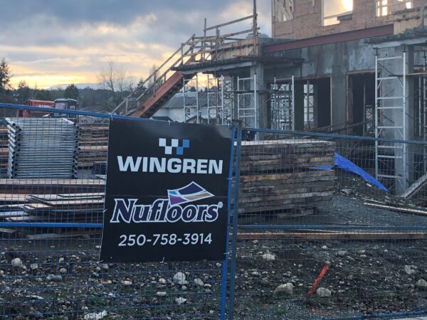 A construction site with Wingreen Nufloors board on the fence.